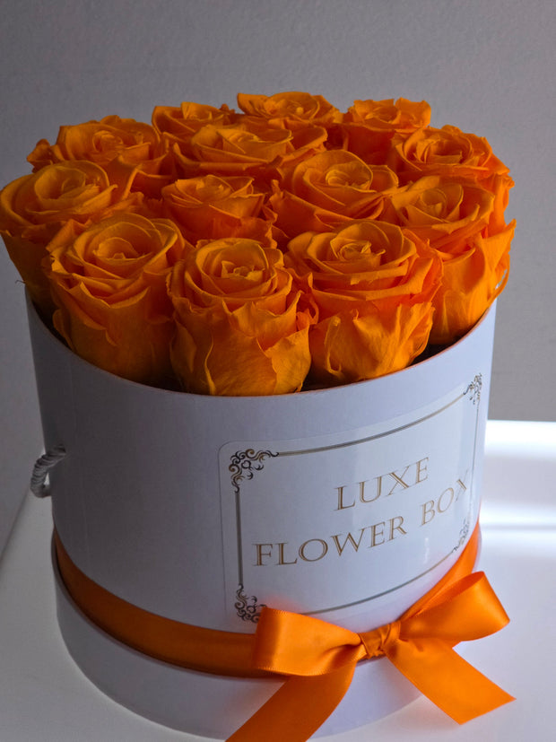 A vibrant Forever Flower Box featuring preserved orange blooms, radiating energy and boldness, perfect for making a lasting statement with its striking and fiery hues.