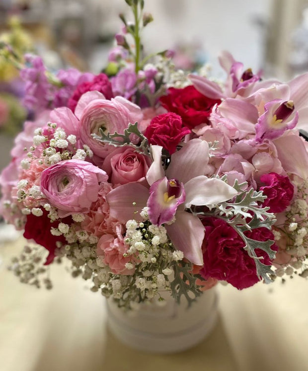 Shades of Pink arrangement with orchids, ranunculus, roses, Dusty Miller, baby's breath, and carnations in soft pink tones