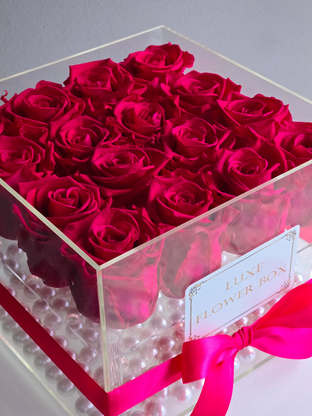 A sleek acrylic flower box showcasing preserved forever roses in vibrant hues, elegantly arranged for a timeless and luxurious display, perfect as a gift or stylish decor piece.