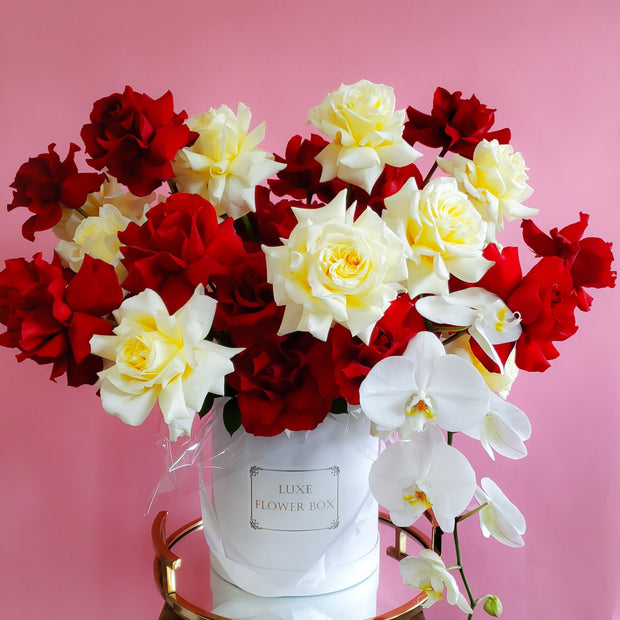 Luxurious French-style floral arrangement featuring elegant roses and delicate orchids, beautifully arranged in a stylish flower box for a sophisticated and romantic touch.