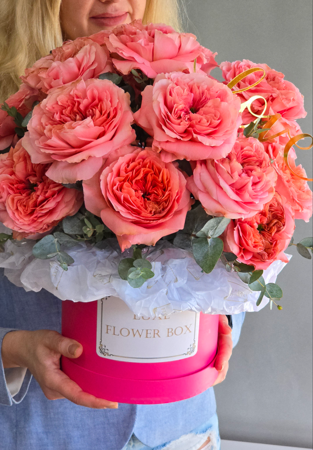 A stunning flower box filled with vibrant pink roses, elegantly arranged to convey love, admiration, and heartfelt emotions, perfect for celebrating special moments or expressing affection.