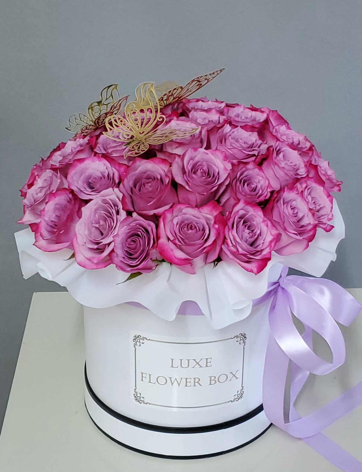 A luxurious box filled with elegant roses in soft, roseate hues, arranged beautifully to exude sophistication and timeless charm, perfect for any special occasion or heartfelt gesture.