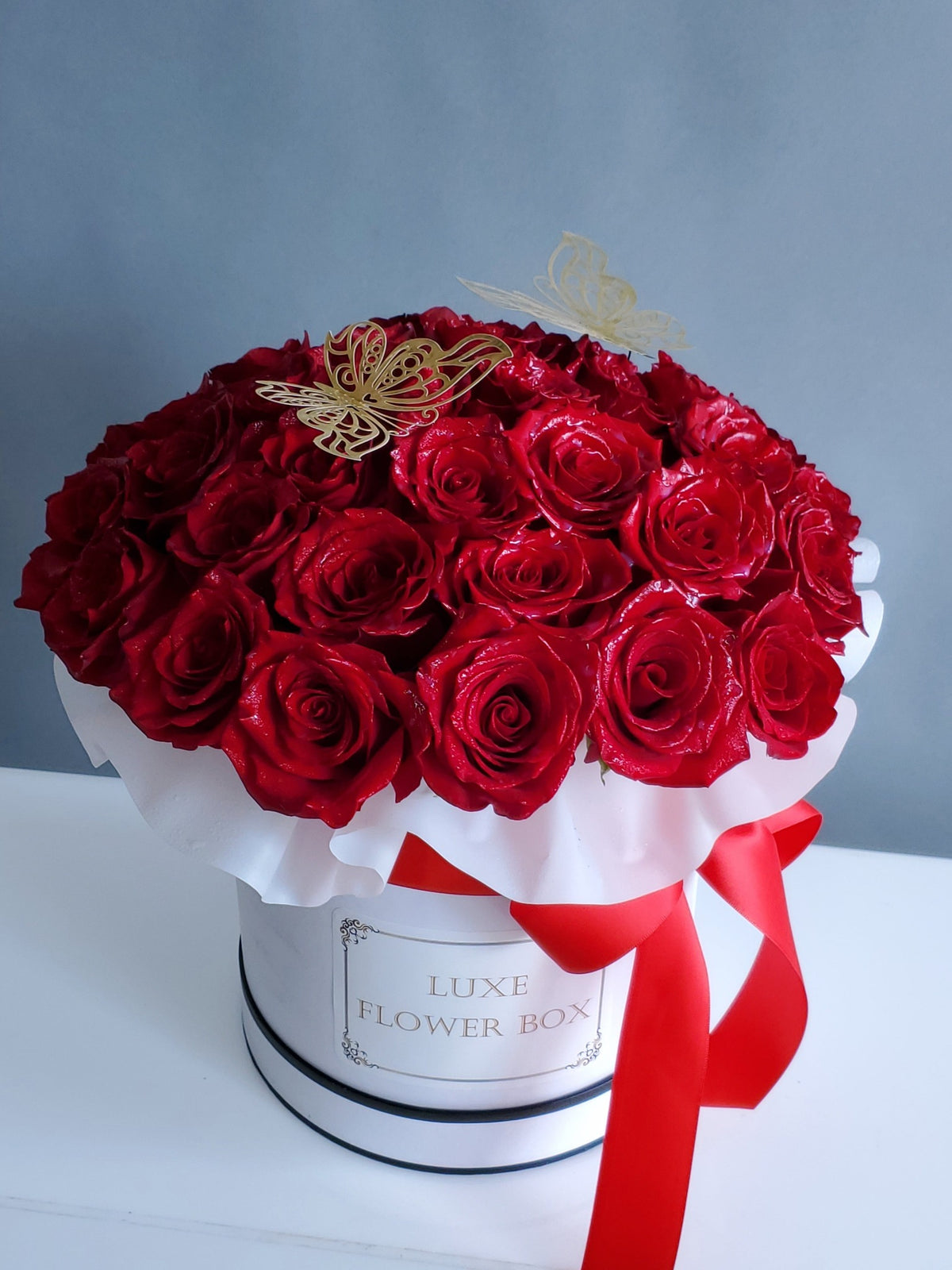 A luxurious box filled with elegant roses in soft, roseate hues, arranged beautifully to exude sophistication and timeless charm, perfect for any special occasion or heartfelt gesture.