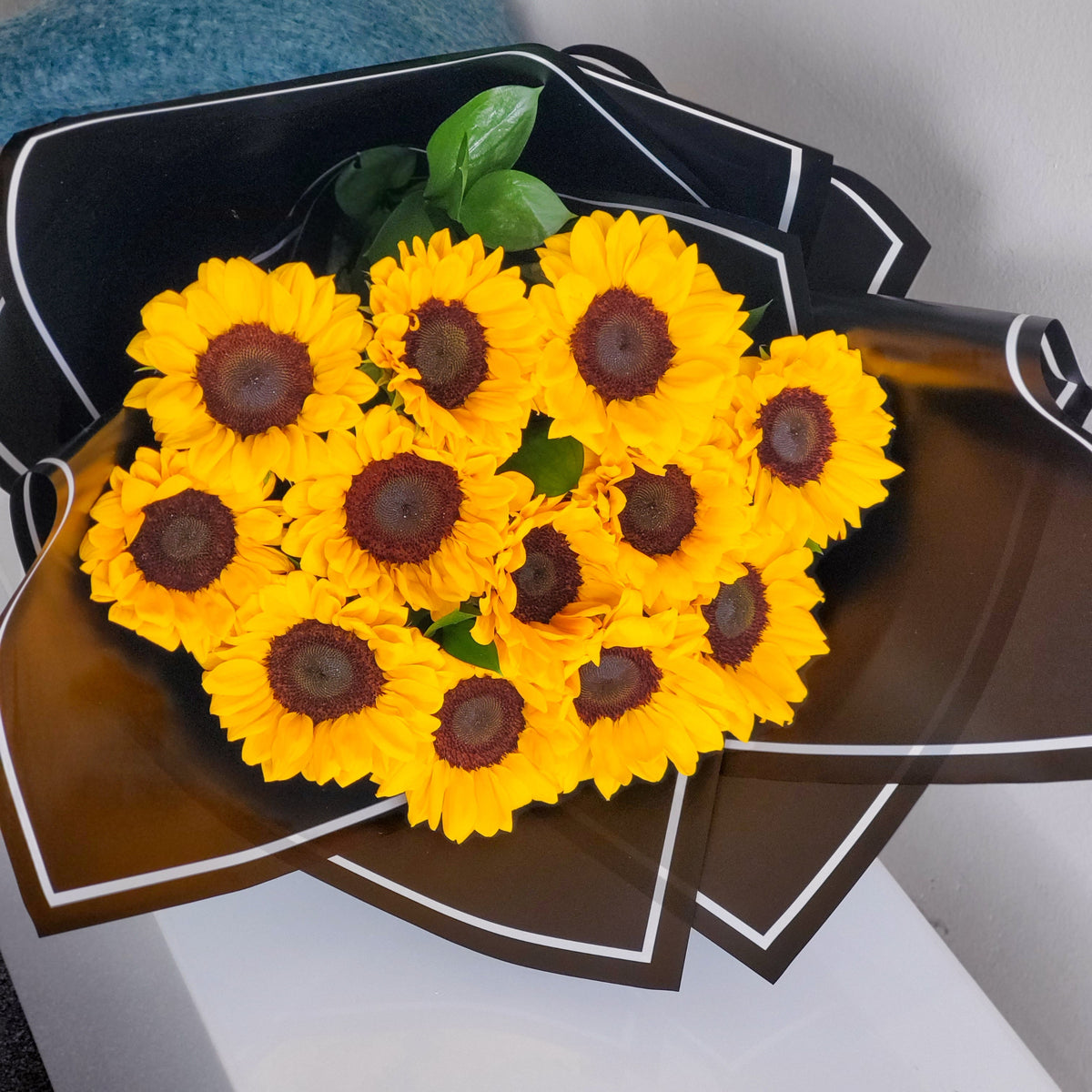 Vibrant bouquet of sunflowers, showcasing their bright golden petals and lush greenery, radiating warmth and happiness.