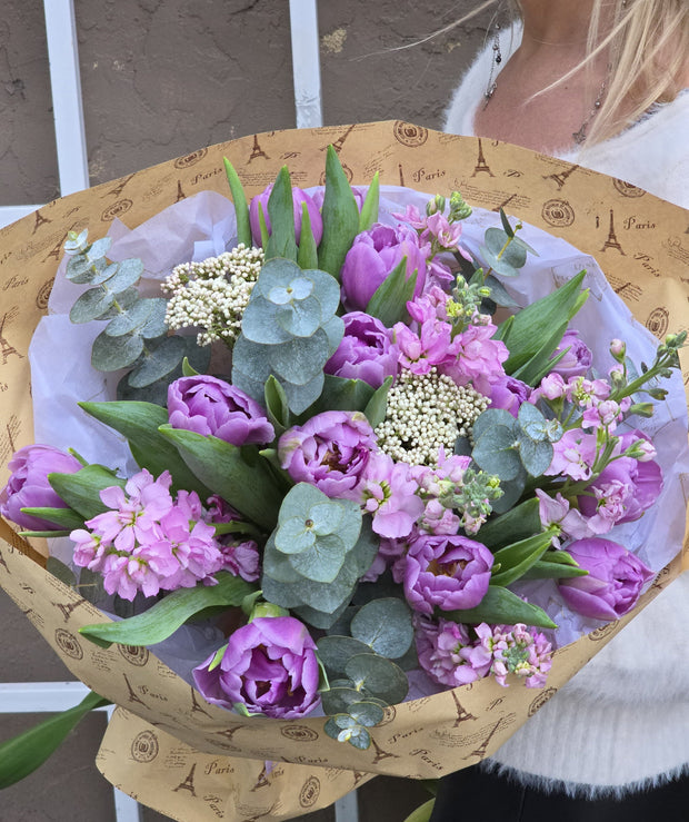 Violet bouquet featuring peony double tulips, stock, and eucalyptus for a lush and elegant look.